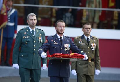 Los representantes del Ejército español portan la bandera nacional antes de la ceremonia de izado al inicio de los actos del Día de la Fiesta Nacional.