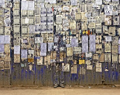 En una pared de información, esta obra pertenece a la serie 'Oculto en la ciudad' de Liu Bolin.