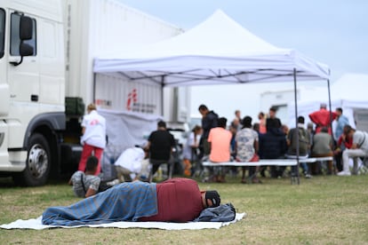 Un hombre descansa frente a un punto de acogida de la organización "Médicos Sin Fronteras" en el centro nacional de asilo Ter Apel, este viernes.