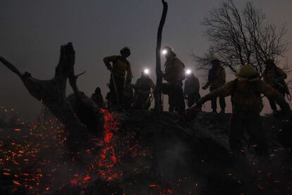 Bomberos trabajan en labores de extinción de un incendio forestal en  Melipilla, al suroeste de Santiago. 