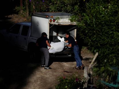 Dos agentes recogen el cuerpo de un asesinado en San Salvador. 