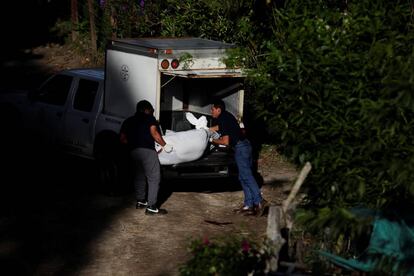 Dos agentes recogen el cuerpo de un asesinado en San Salvador.