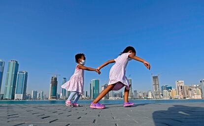 Meninas caminham à beira-mar no distrito de al-Mamzar, em Dubai, em 14 de maio, após flexibilização das medidas de bloqueio da pandemia.