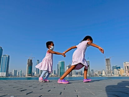 Meninas caminham à beira-mar no distrito de al-Mamzar, em Dubai, em 14 de maio, após flexibilização das medidas de bloqueio da pandemia.