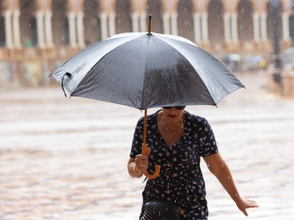 Una mujer se protege de las fuertes lluvias de la anterior dana, el domingo 3 de septiembre en Valencia.