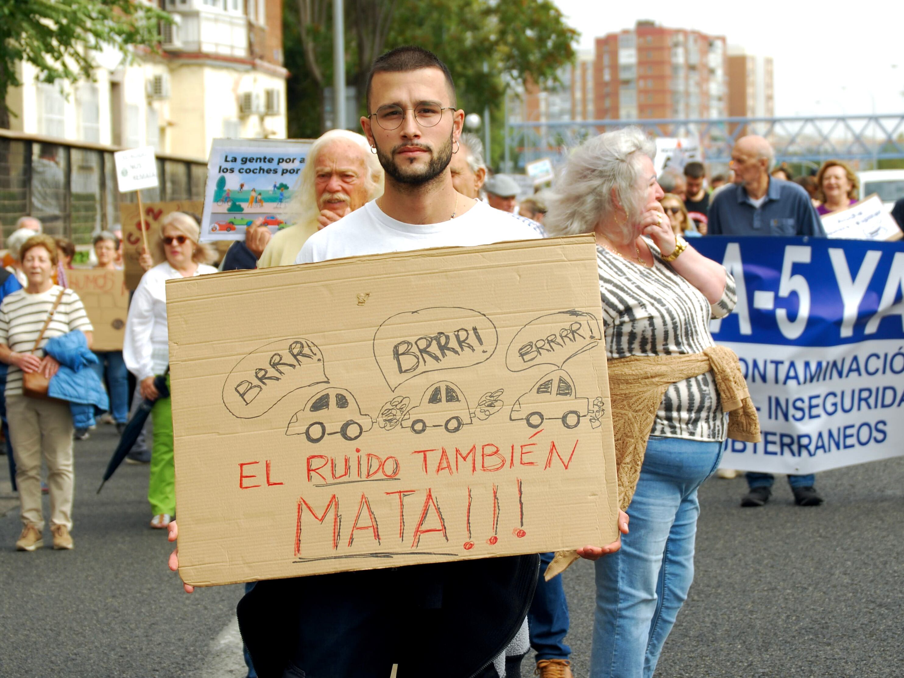 Álvaro Vicente sostiene un cartel en protesta por el ruido de la A-5 que sufren los vecinos de Campamento y Aluche en la manifestación de este domingo.