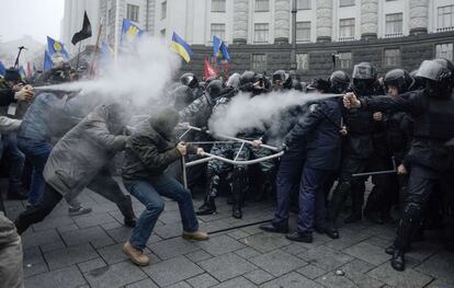 24 de noviembre de 2013. Manifestantes y agentes de policía se lanzan gases lacrimógenos durante las protestas en Kiev.