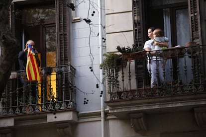 Veïns de l'edifici més afectat per les flames al balcó de casa seva, on es pot veure que el foc va arribar als testos.