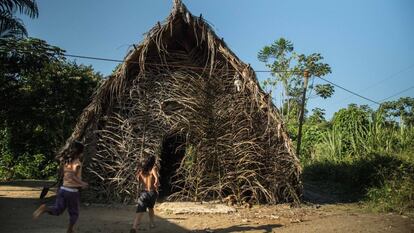 La pequeña comunidad waorani no repara en el calor ni en la humedad en Gareno, donde sus integrantes residen en casas de madera rodeadas de vegetación frondosa. En la imagen, unos niños corren hacia una cabaña tradicional en Gareno.