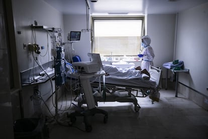 En el Gregorio Marañón, como en el resto de hospitales de Madrid, las unidades de cuidados intensivos han sido el punto crítico: allí viven o mueren los pacientes más graves, los que no pueden respirar por sí mismos. Algunos de ellos necesitan de una maniobra de pronación, es decir, mantenerse bocabajo para disminuir la presión sobre los pulmones y facilitar la respiración. Esta técnica, una de las más complicadas de Intensivos, requiere de una destreza extrema para que, al dar la vuelta al paciente, no haya ningún fallo en la intubación ni en el resto de vías y cables que lo mantienen conectado al respirador que registra todas sus constantes. En la imagen, un paciente pronado en una habitación de UCI del Gregorio Marañón.