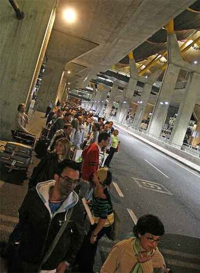 Viajeros esperando un taxi en la T-4 a la 1.30 del lunes.