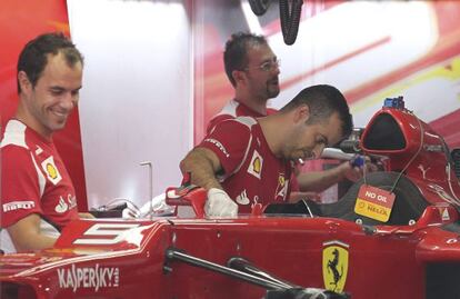 Miembros de Ferrari trabajan en el monoplaza en el Circuito Internacional Buddh