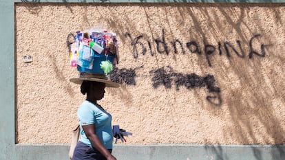 Una mujer pasa junto a un grafiti en el que se lee "Abajo los secuestros", el 16 de febrero en Puerto Príncipe (Haití).