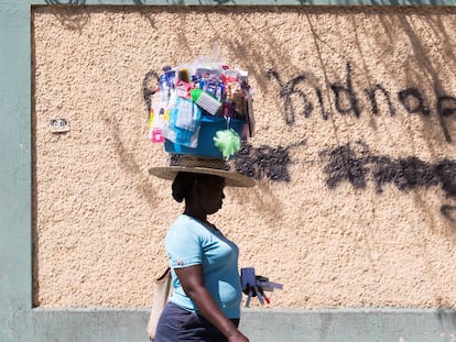 Una mujer pasa junto a un grafiti en el que se lee "Abajo los secuestros", el 16 de febrero en Puerto Príncipe (Haití).