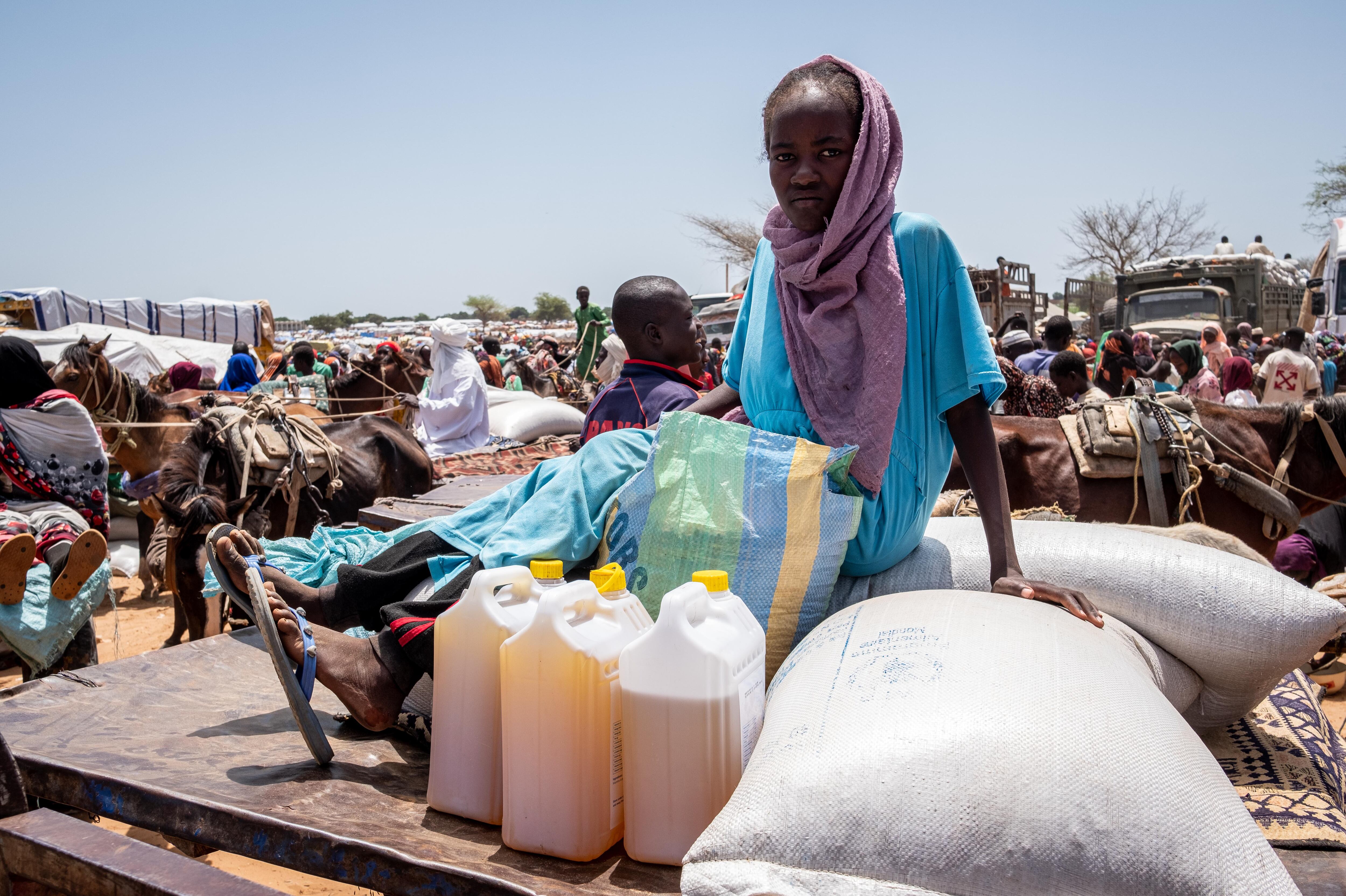 El grupo de refugiados solamente puede venir a por comida si está registrado en un mostrador de Acnur. Unas pequeñas tarjetas, firmadas con una huella dactilar y distribuidas por familia, indican a qué productos tienen derecho. La comida debe alcanzarles para un mes. Como no hay estructura en el campamento, no hay líderes comunitarios ni ancianos que estructuren cómo se organiza el lugar. En cuanto recogen el aceite, los guisantes y el sorgo, la mayoría de los refugiados pagan una pequeña parte de los alimentos que acaban de conseguir a hombres con carros tirados por burros, que luego transportarán la mercancía a sus improvisados hogares.