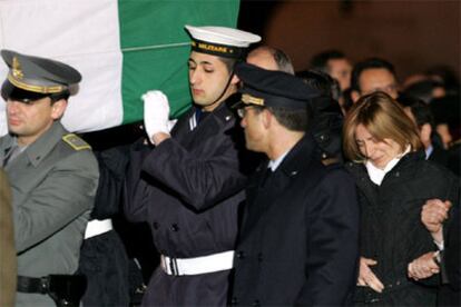 La esposa del policía muerto ha recibido junto a las autoridades el féretro a su llegada a Roma.