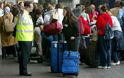 Varios pasajeros esperan en el aeropuerto londinense de Heathrow tras cancelarse su vuelo a Washington.