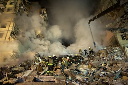 Los trabajadores de emergencia limpiaban los escombros después de que un cohete ruso impactara en un edificio de varios pisos dejando a varias personas sepultadas, en la ciudad de Dnipro, al sureste de Ucrania, el 14 de enero.