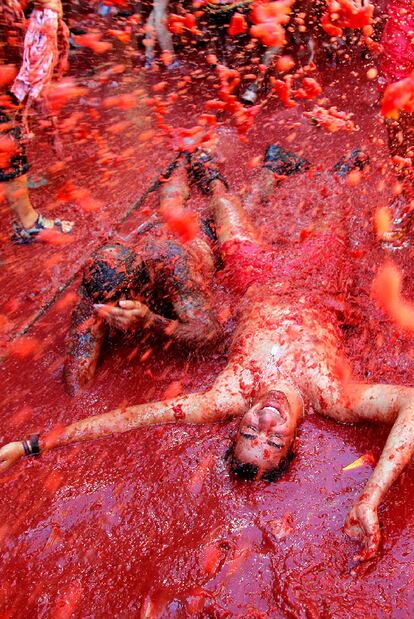 Un festero se bañaba ayer en la sopa de tomate y agua en la Tomatina de Buñol.