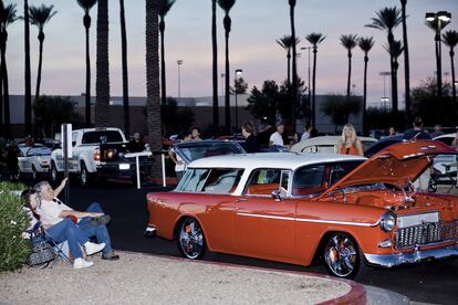 Pareja sentada junto a su Chrysler vintage durante una exhibición semanal de vehículos antiguos