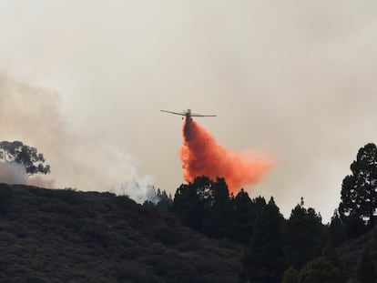 Una avioneta descarga sobre un incendio en la zona del Pico de las Nieves, en Gran Canaria, este martes.