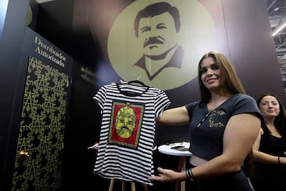 Una mujer sostiene una blusa en el stand de la marca "El Chapo 701", que es propiedad de la hija de Guzmán Loera, durante el evento Intermoda en Guadalajara, México.