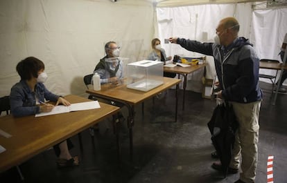Un hombre enseña el DNI este domingo en un colegio electoral de Ordizia (Gipuzkoa), durante la jornada electoral de los comicios autonómicos en la que se extreman las medidas de seguridad para votar por el coronavirus.