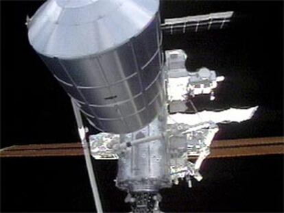 Imagen de televisión del brazo robótico de la ISS que traslada equipo al transbordador Endeavour.