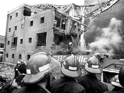 Bomberos observan los restos de la casa cuartel de la Guardia Civil de Zaragoza tras el atentado del 11 de diciembre de 1987, en el que murieron 11 personas.