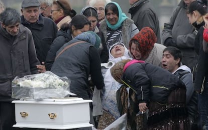 La madre de la beb&eacute; fallecida, junto a otros familiares, durante el entierro este lunes en Wissous.