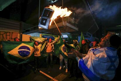 Unos manifestantes prenden fuego a un modelo de dispositivo de votación electrónico en Sao Paulo, Brasil.