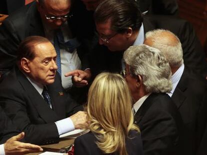 Berlusconi habla con otros senadores en el voto de confianza a Letta.