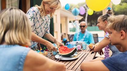 Una familia celebrando una fiesta de cumpleaños con fruta.