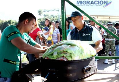 Un miembro de Aduanas de Colombia revisa el equipaje de un hombre que cruza la frontera desde Venezuela, en el puente Simón Bolívar en Cúcuta.