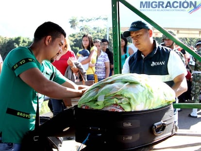 Un miembro de Aduanas de Colombia revisa el equipaje de un hombre que cruza la frontera desde Venezuela, en el puente Sim&oacute;n Bol&iacute;var en C&uacute;cuta.