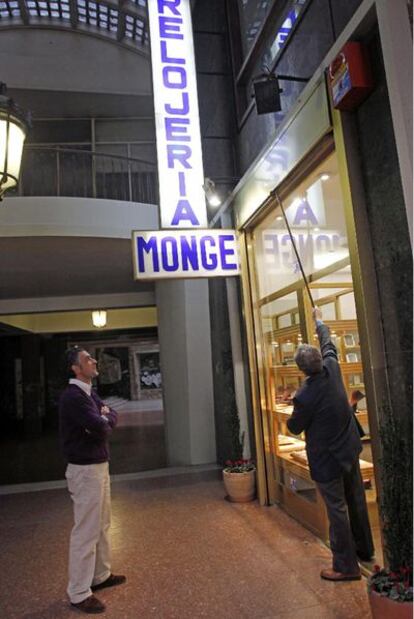 Eugenio Monge (a la izquierda), ante su joyería en el pasaje de Fuencarral, observa su negocio.