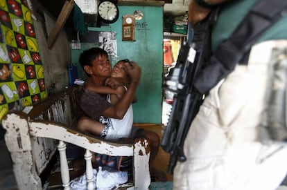 Una mujer acusada de narcotráfico llora abrazada a su hijo antes de ser arrestada por miembros de la Agencia Antinarcóticos de Filipinas, durante una redada en Pasay (Filipinas).