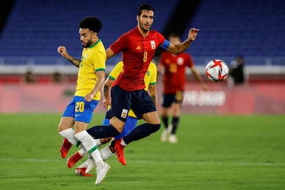 El centrocampista español Mikel Merino pelea por el balón ante el centrocampista brasileño Claudinho.