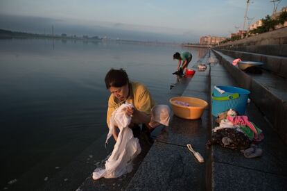 Mujeres chinas lavan sus ropas en el río, cerca del Puente de la Amistad Sinocoreana, en Dandong.