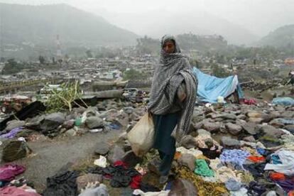 Una víctima del terremoto busca plásticos con los que construir un refugio para sus hijos en Balakot.