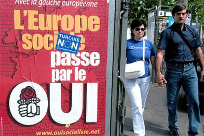 Una pareja pasa junto a los carteles electorales en una calle de París vísperas de la votación.