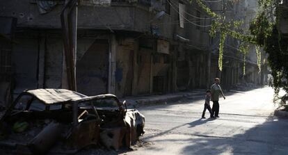 Un hombre y un ni&ntilde;o caminan por la zona rebelde de Ain Tarma, en Ghuta, al este de Damasco.