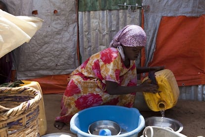 Habibo Mohammed Suso, de 25 años y víctima de mutilación genital, lava los utensilios de cocina en el campo de refugiados de Al-Cadaala, en Mogadiscio.