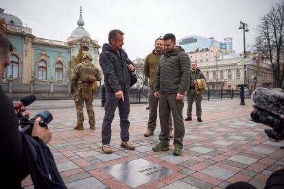 El actor Sean Penn señala la placa conmemorativa a su nombre mientras charla con el presidente de Ucrania en la ciudad de Kiev.  