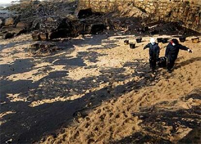 Un grupo de voluntarios limpian la playa de Muxia del fuel derramado por el &#39;Prestige&#39;.