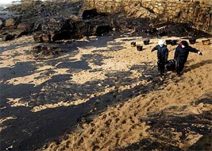 Un grupo de voluntarios limpian la playa de Muxia del fuel derramado por el 'Prestige'.