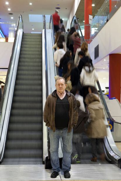 Fermín Bouza ante la escalera mecánica de un centro comercial.