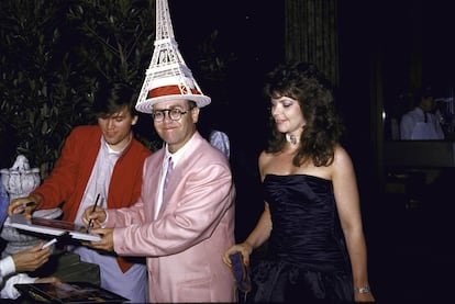 Elton John, con una Torre Eiffel en la cabeza, firma discos acompañado de su entonces esposa, Renate Blauer, en 1986.