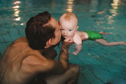 Un padre en la piscina con su bebé.