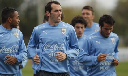 En primer plano, el mediocampista Álvaro Pereira, que juega esta temporada en el Estudiantes de La Plata argentino cedido por el Inter de Milán, y el defensa Diego Godín, figura del Atlético de Madrid. Ambos se entrenan con su selección en el departamento de Canelones (50 kilómetros al norte de Montevideo) en la previa del partido contra Colombia. Ni Suárez ni Cavani participarán, ambos sancionados.